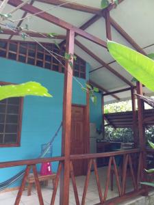 a house with a blue wall and a porch at Luna Caribeña Village in Puerto Viejo