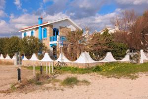 a house on the beach with a fence in front of it at La Casa Sulla Spiaggia in Flumini di Quartu