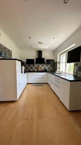 uma grande cozinha com armários brancos e piso em madeira em Cloud 9 em Dreieich