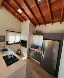 eine Küche mit einem Kühlschrank aus Edelstahl und Holzdecken in der Unterkunft Casa em Bom Jardim da Serra in Bom Jardim da Serra
