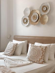 a bed with white pillows and mirrors on the wall at Lindos Athena in Lindos
