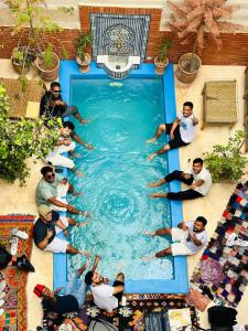 un grupo de personas sentadas alrededor de una piscina en Riad 46, en Marrakech