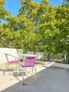 dwa krzesła i stół na patio z drzewem w obiekcie Departamento de 2 amb. en Lomas Centro con terraza w mieście Lomas de Zamora