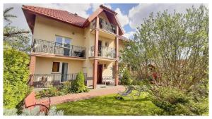 a large house with balconies and a yard at Willa Mazowiecka Jantar in Jantar