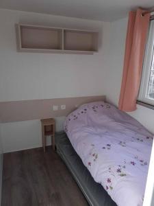 un piccolo letto in una camera con finestra di Mobil-home CLOS 18 à VIAS a Vias