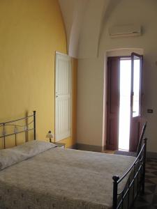 ein Schlafzimmer mit einem großen Bett und einer Tür in der Unterkunft B&B Camera A Sud Tuglie Gallipoli in Tuglie