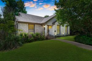 a house with a green lawn in front of it at Sunset House - Luxury Pool and Hot Tub Retreat in Dallas