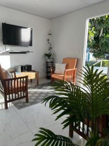 d'un salon avec des chaises et une télévision à écran plat. dans l'établissement ARNAS HOME, à San Andrés
