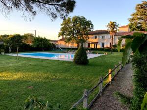 a fence in front of a yard with a swimming pool at La Lauze in Vielmur