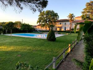 a fence in front of a yard with a swimming pool at La Lauze in Vielmur-sur-Agout
