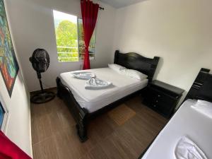 a small bedroom with a bed and a window at Hostal Recuerdos del Tayrona in El Zaino