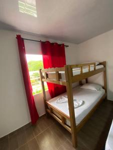 a bedroom with two bunk beds and a window at Hostal Recuerdos del Tayrona in El Zaino