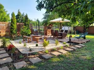 a backyard with a table and chairs and an umbrella at Nárcisz Vendégház 2 in Mezőkövesd
