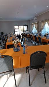 a room with long tables and chairs with glasses at LALA POA GUEST HOUSE in Klerksdorp