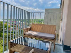 a balcony with a rattan chair and a glass table at 55 m2 Stylish Apartment with Balcony and Netflix in Vienna