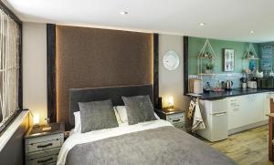 een slaapkamer met een groot bed en een keuken bij Beautiful studio apartment near the Norfolk Broads in Rackheath