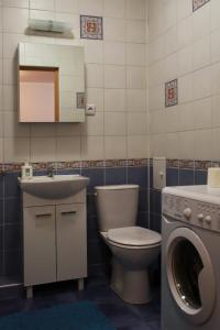 a bathroom with a toilet and a sink and a washing machine at Mieszkanie Warszawa 3 in Warsaw
