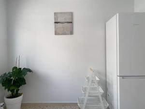 - une cuisine blanche avec une échelle à côté d'un réfrigérateur dans l'établissement Faliro comfort apartment 10 mins walking to the beach, à Athènes