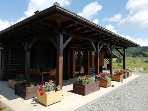 een paviljoen met bloemen in dozen op een patio bij Chata gościom rada in Ustrzyki Dolne