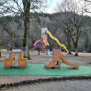 a playground with two slides and a play equipment at Villa Bella à 300 m du Parc Fenestre in La Bourboule