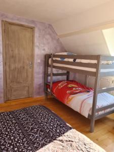 a bedroom with two bunk beds and a rug at Villa Bella à 300 m du Parc Fenestre in La Bourboule