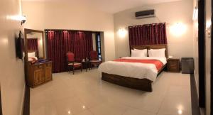 Habitación de hotel con cama, mesa y sillas en Hotel Inn Karachi en Karachi
