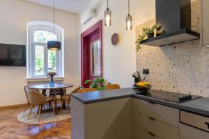 Una cocina con una mesa y un comedor. en Polai Park Apartments, en Pula