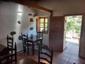 Casa Rural Chamorga في سانتا كروث دي تينيريفه: غرفة طعام مع طاولة وكراسي وباب