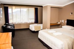 een hotelkamer met 2 bedden en een raam bij Fiordland Hotel in Te Anau