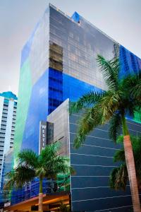 un edificio de cristal alto con palmeras delante en The Westin Panama, en Panamá