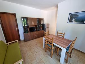 a kitchen and dining room with a wooden table and chairs at Appartamento Mario in Sirolo