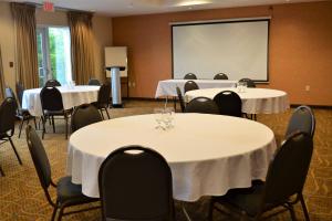 a conference room with tables and chairs and a screen at Fairfield Inn & Suites by Marriott Sault Ste. Marie in Sault Ste. Marie