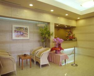- une salle d'attente avec des chaises, une table et des fleurs dans l'établissement Hotel Route-Inn Naha Asahibashi Eki Higashi, à Naha