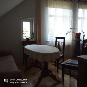 ein Wohnzimmer mit einem Tisch, Stühlen und einem Fenster in der Unterkunft Zofiówka in Stare Jabłonki