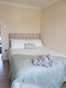 Stylish 2 Bed Flat in Hoxton near Art Galleries في لندن: غرفة نوم عليها سرير بثلاث مخدات