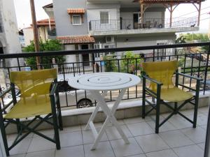 d'une table et de deux chaises sur un balcon. dans l'établissement Vasiliki Holidays Private Apartment Chalkidiki, à Flogita