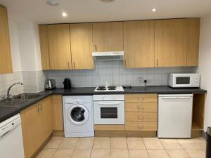 a kitchen with a washing machine and a microwave at Queenstown road in London