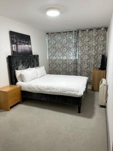 a bedroom with a bed with white sheets and pillows at Queenstown road in London