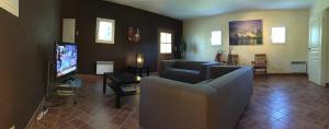 uma sala de estar com dois sofás e uma televisão em Mas le Pénéquet em Aubignan