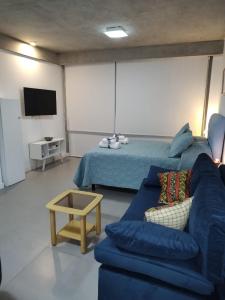 sala de estar con sofá azul y cama en Palermo Scent 2 en Buenos Aires