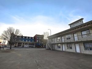 un aparcamiento vacío frente a un edificio en Capone's Hideaway Motel, en Moose Jaw