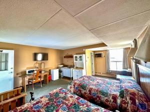 a hotel room with two beds and a kitchen at Capone's Hideaway Motel in Moose Jaw