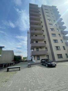 a car parked in front of a large building at West View by DAT Apartments in Cluj-Napoca