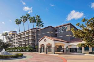 um edifício de hotel com palmeiras ao fundo em Four Points by Sheraton Anaheim em Anaheim