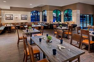uma sala de jantar com mesas e cadeiras e um restaurante em Four Points by Sheraton Anaheim em Anaheim