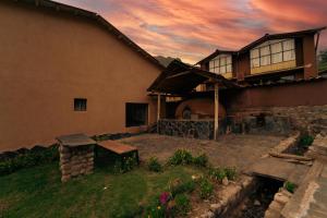 a house with a bench in front of it at Casa cabaña privada en el Valle Sagrado Urubamba in Urubamba