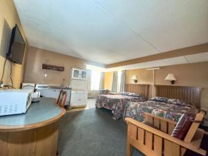 a hotel room with two beds and a sink at Capone's Hideaway Motel in Moose Jaw