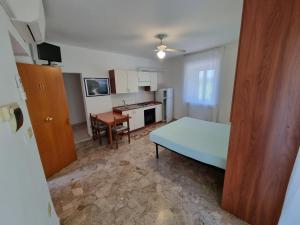 a small room with a bed and a kitchen at Appartamento Mario in Sirolo