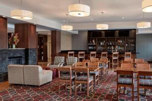 a restaurant with tables and chairs and a fireplace at Four Points by Sheraton Regina in Regina