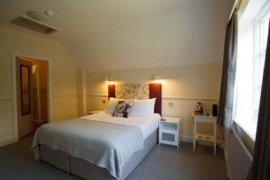 a bedroom with a large white bed with a window at The Egerton Arms in Chester